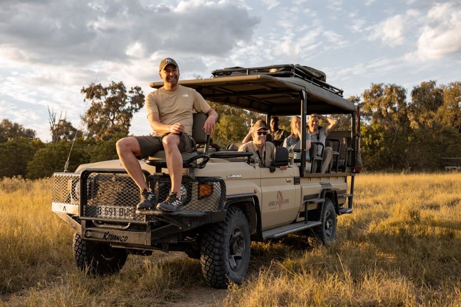 A participant sitting on the front of the safari vehicle